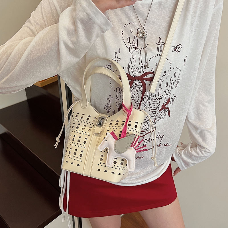 Nicho de diseño hueco bolsa de canasta de verduras para mujeres 2025 verano nueva moda alta sensación bolso de cubo de agua