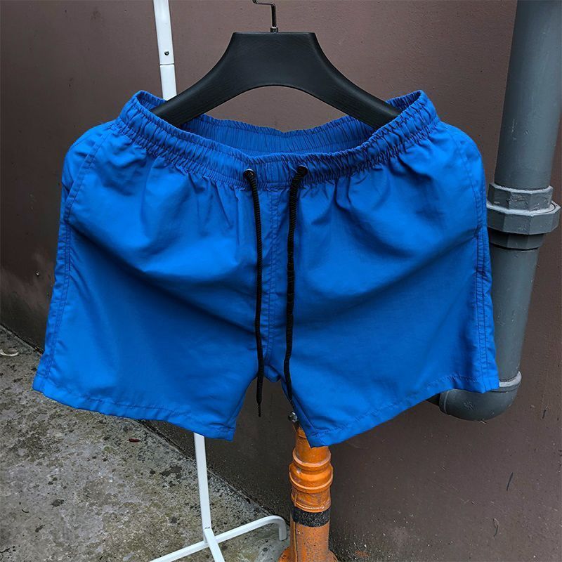 Pantalones de cuatro puntos Pantalones cortos casuales de verano para hombres Pantalones de playa de color caramelo para hombres de moda Pantalones de tres puntos deportivos sueltos de secado rápido