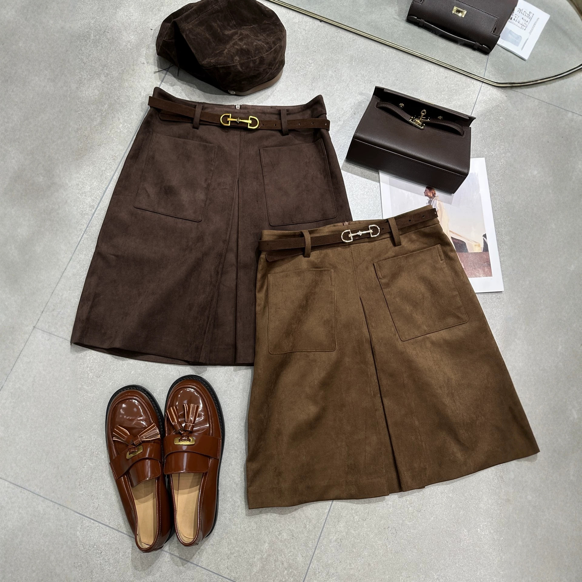 Autumn and winter suede skirt with a metal buckle belt and large pockets, featuring a retro style and a mid-length A-line silhouette