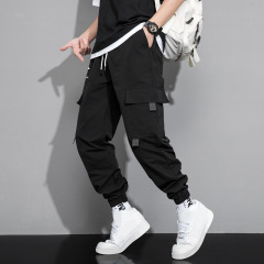 春秋の男性のズボンの新型のファッションのゆったりしている工装のズボンはアウトドアの多ポケットのカジュアルな工装のズボンに合わせます。