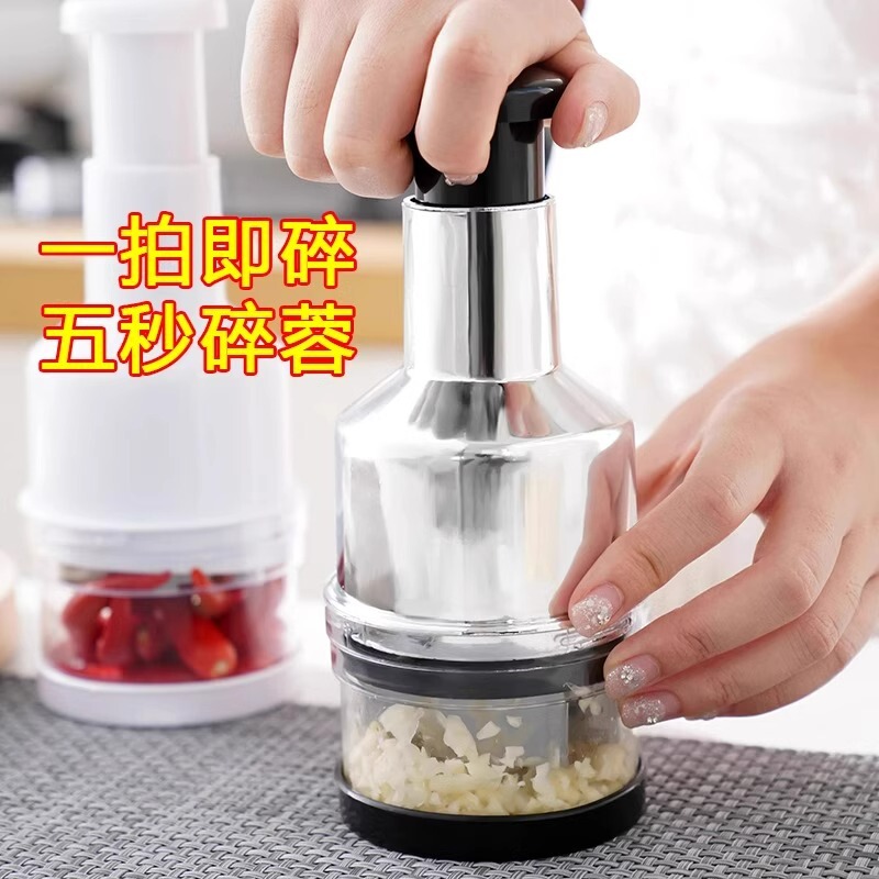 ナイフをたたいてステンレスの手押し式の野菜切り器の台所は手動でニンニクの泥をいじります。|undefined