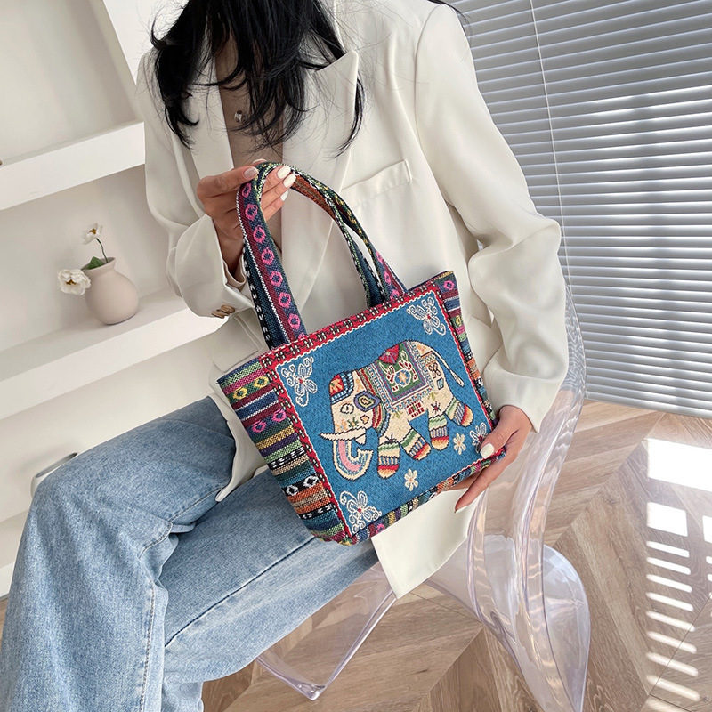 国境を越えた刺繍キャンバスのハンドバッグは女性民族風のハンドバッグを持ってカジュアルなマミーバッグのサラリーマンが弁当袋を持っている|undefined