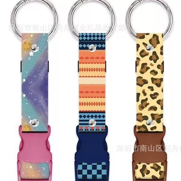Polyester heat-transfer webbing, paired with a plastic quick-release buckle and a metal key ring, creates a versatile bag charm and multi-functional lanyard