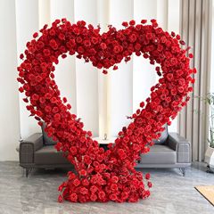 ハート型の棚の花芸の結婚式の背景の舞台は花棚のプロポーズ活動の祝典の装飾を並べて花の赤い愛をシミュレーションします。
