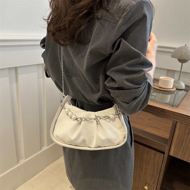 Diseño de nicho francés 2024 nuevo color sólido simple cadena de perlas de aire extranjero plegado versátil bolso de mochila pequeña moda