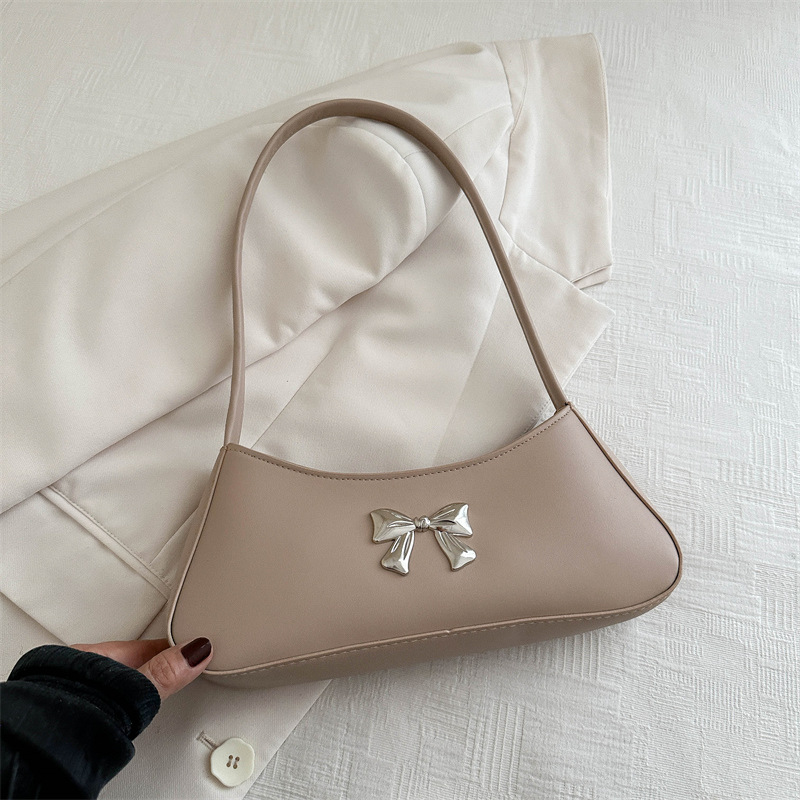 Bolsos axilales de alta textura 2024 verano nuevo diseño de moda francesa temperamento simple arco bolso de hombro