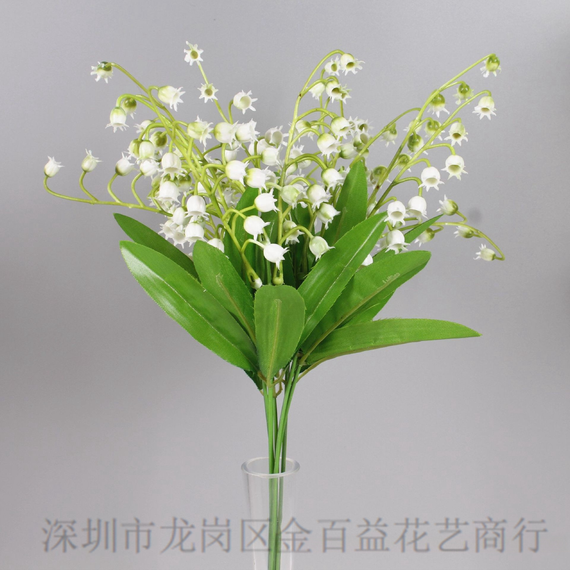 El viento del interior sostiene un ramo de lirio de los valles, flores artificiales frescas, flores de plástico blancas, mesa de comedor, flores falsas, flores decorativas, flores