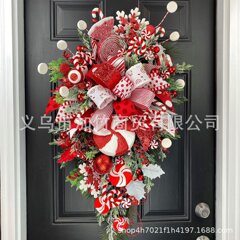 国境を越えて独立した駅の新しいクリスマスキャンディー蝶ネクタイが木のクリスマスドアを掛けてクリスマスの壁面装飾を飾っている