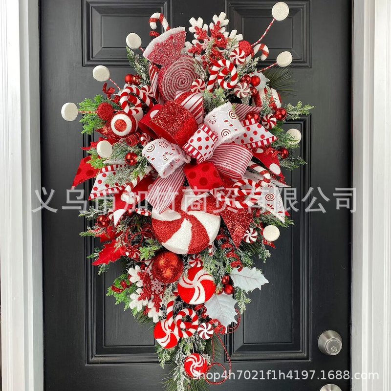 国境を越えて独立した駅の新しいクリスマスキャンディー蝶ネクタイが木のクリスマスドアを掛けてクリスマスの壁面装飾を飾っている|undefined