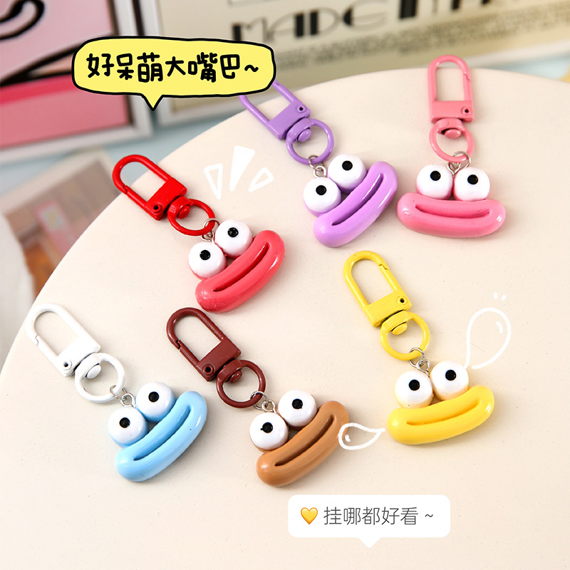 かわいいアニメの大きな口のキーホルダーは学生のカバンを飾っています。