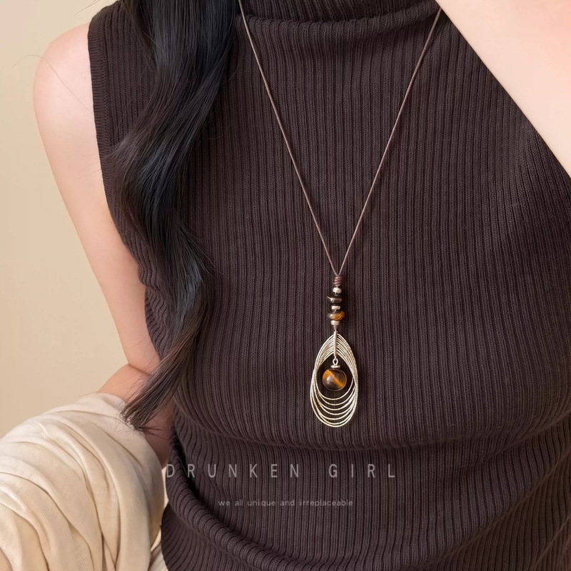 Autumn and winter retro tiger's eye stone and golden feather pendant necklace, a sophisticated and luxurious accessory for women, perfect for pairing with sweaters, and available in a long chain style Autumn and winter retro tiger's eye stone and golden feather pendant necklace, a sophisticated and luxurious accessory for women, perfect for pairing with sweaters, and available in a long chain style