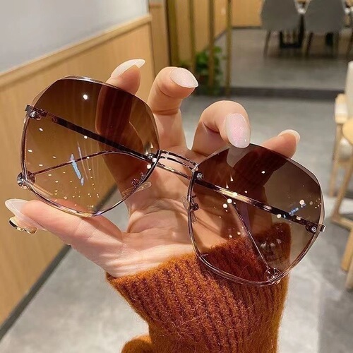 New trendy flat-framed sunglasses with irregular edge and gradient lenses, popular among women for decorative purposes.