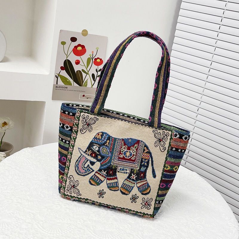 国境を越えた刺繍キャンバスのハンドバッグは女性民族風のハンドバッグを持ってカジュアルなマミーバッグのサラリーマンが弁当袋を持っている|undefined