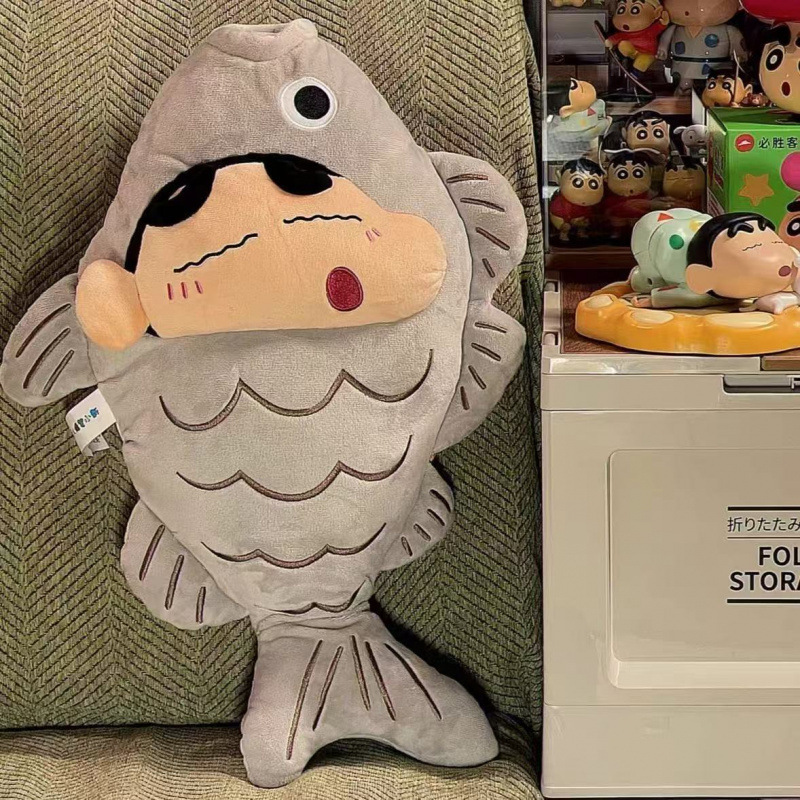 クレヨンしんちゃんのぬいぐるみぬいぐるみの小魚is小衆の机の上に物を並べて誕生日の祭りに友達を送ります。|undefined
