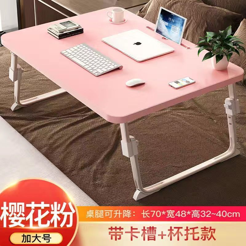 ベッドの上の小さい机のノートパソコンの机の上で折り畳みます。|undefined