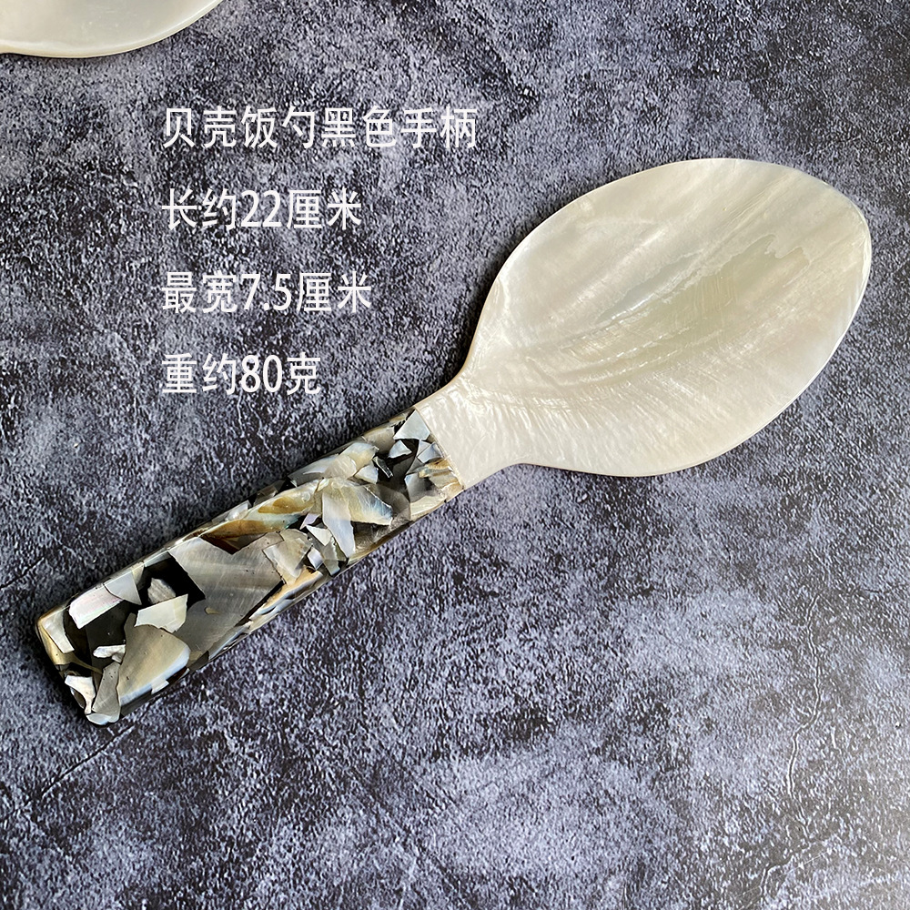 검은색 손잡이가 달린 흰색 조개밥숟가락