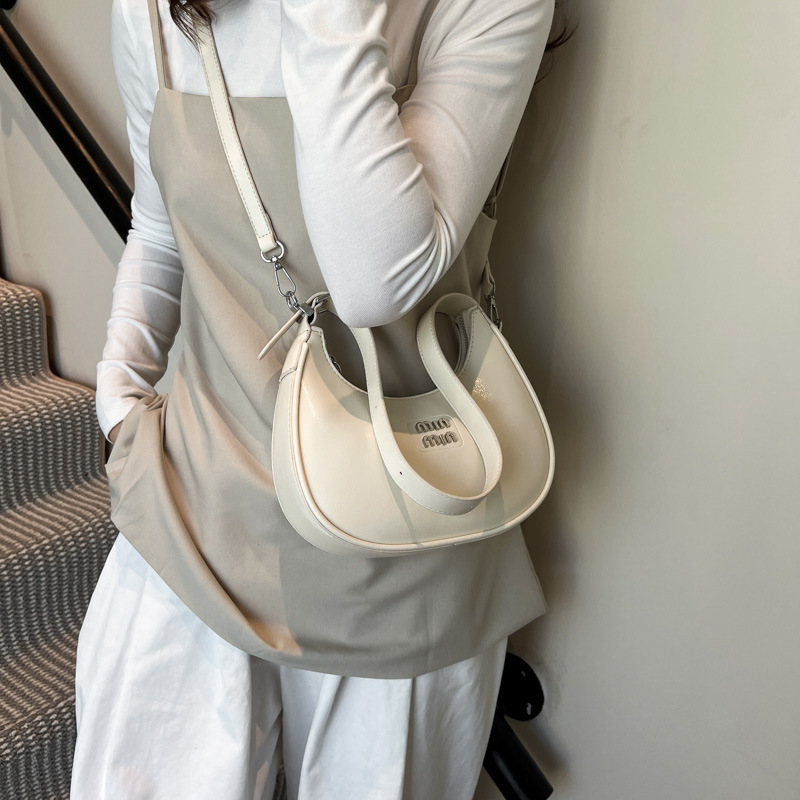 Bolso de axila de fuego súper transfronterizo para mujer 2025 nueva versión coreana de la bolsa de media luna de diseño de nicho bolsa de bola de masa cruzada de sentido avanzado