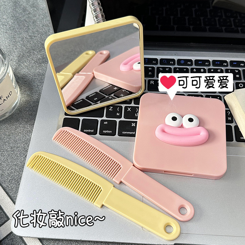 アニメソーセージの口の小さいハンドルの鏡は櫛を持っています。|undefined