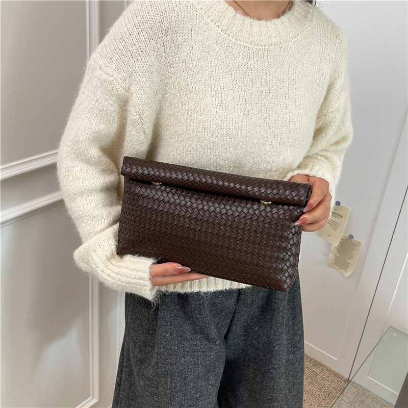 2025 otoño popular trenzado PU bolsos de muñeca bolsos de moda simple bolsos de maquillaje de gran capacidad coreana