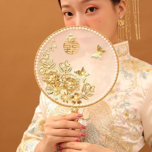 中国式の結婚式の秀禾の顔の団扇の新婦は結婚して花の古風を持って結婚します。|undefined