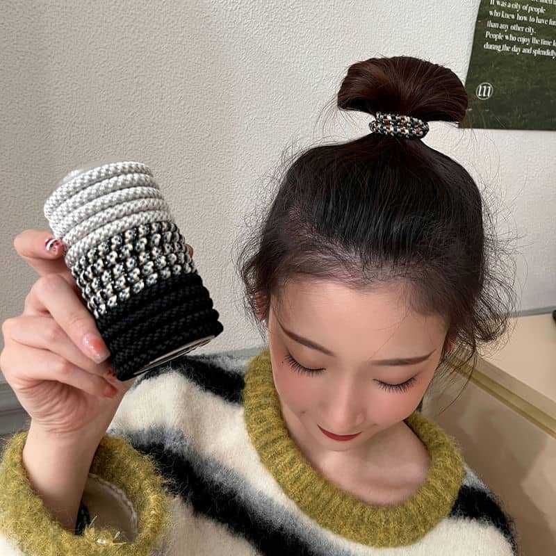 高弾力で耐久性のある運動ヘアリングの女性が髪の筋を刺して太くして、絶えずに頭のひもの高い馬尾の髪の飾りをします。|undefined