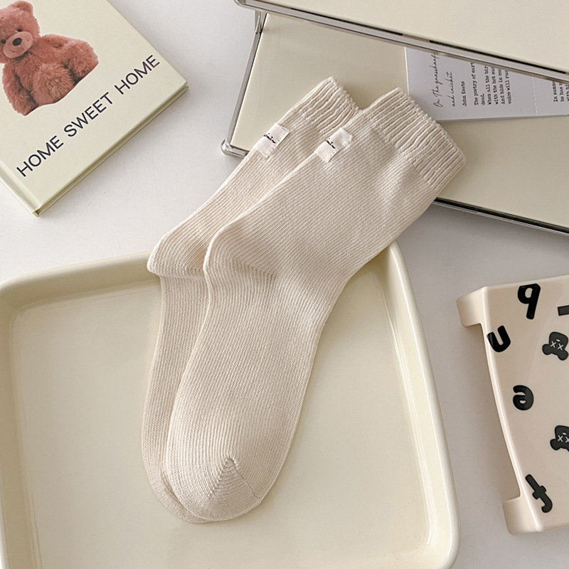 Otoño e invierno Nuevos calcetines de algodón absorbentes de sudor calcetines de pila serie de crema para mujer estilo ins Corea del Sur etiqueta de tela calcetines de media pantorrilla moda