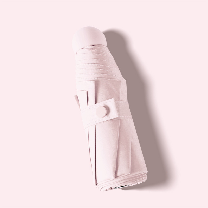 ピンクの丸五つ折りの黒ゴム傘