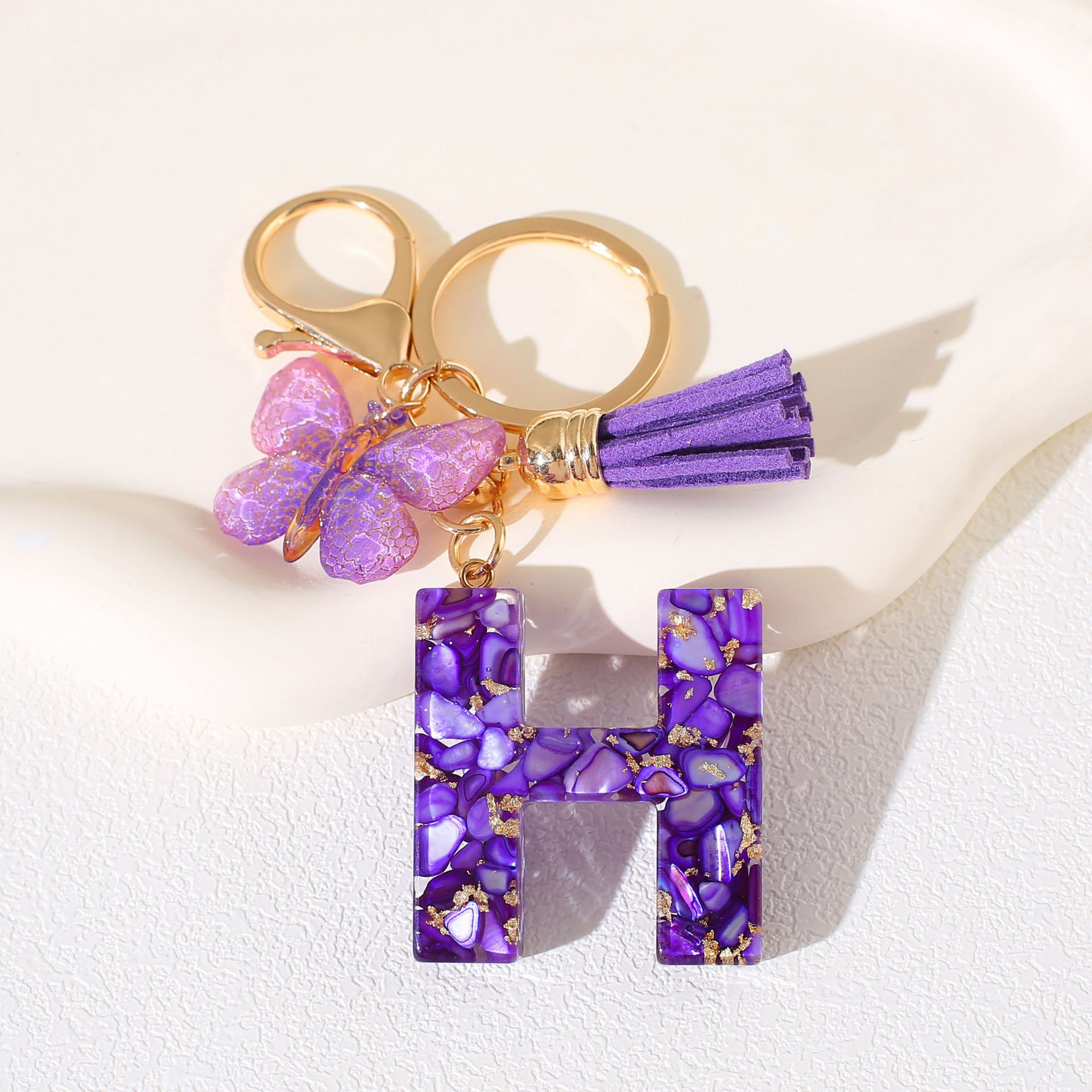 Fábrica directa de Yiwu accesorios de resina de goteo de embalaje llavero anillo de metal letras mariposa brilla colgante damas