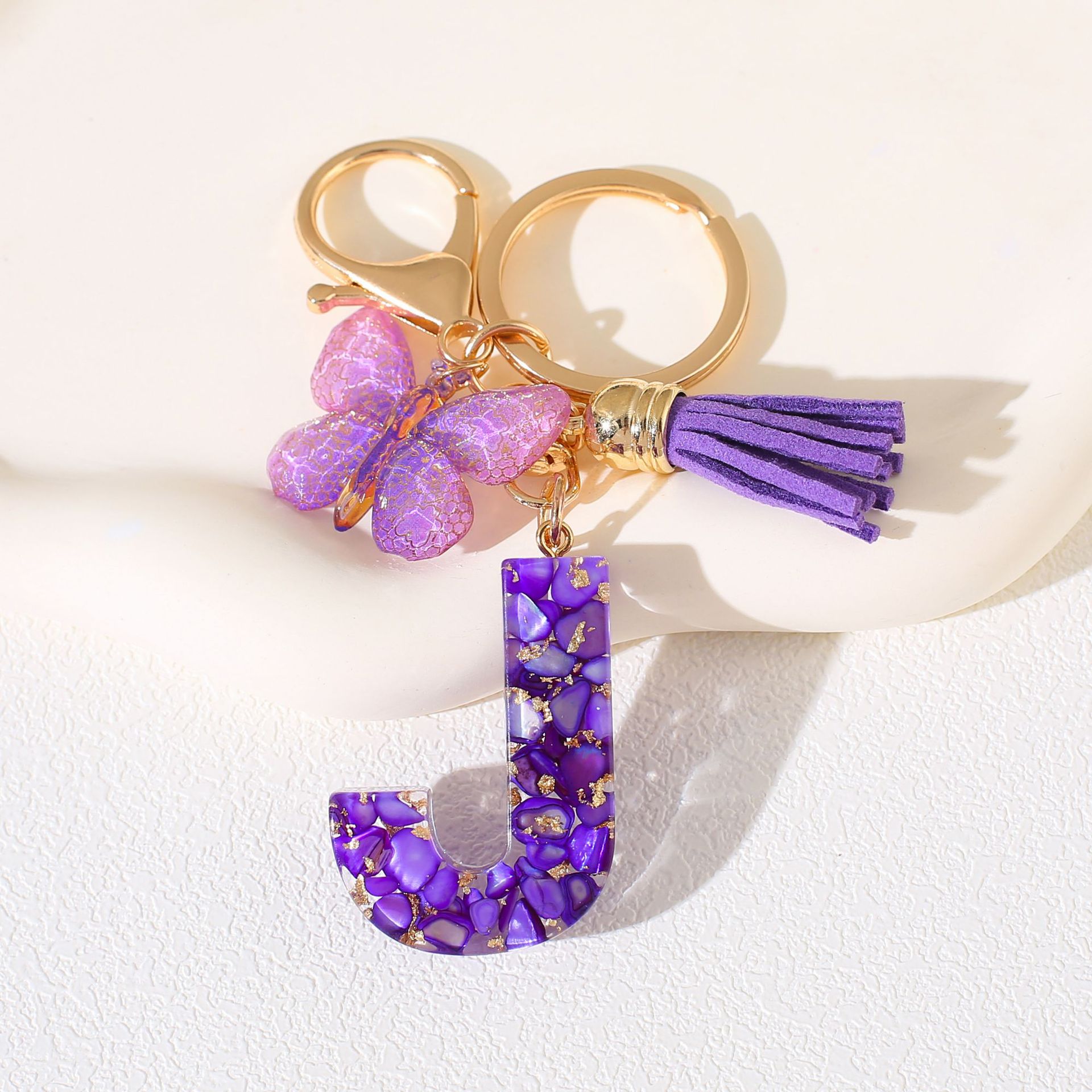 Fábrica directa de Yiwu accesorios de resina de goteo de embalaje llavero anillo de metal letras mariposa brilla colgante damas