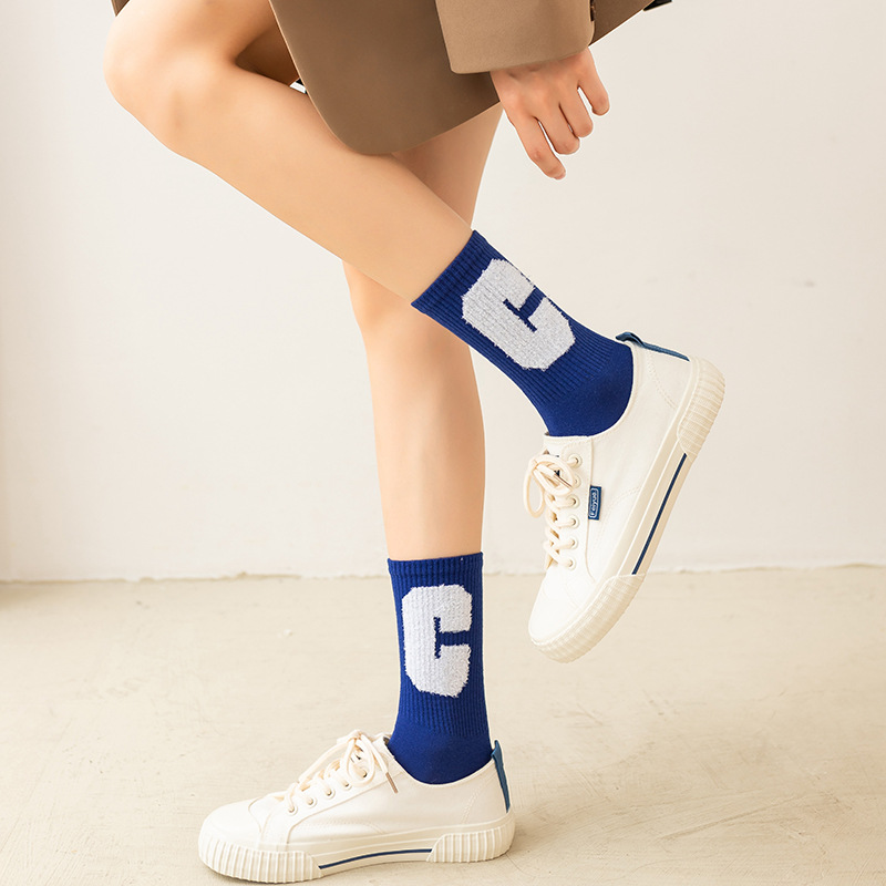 Calcetines de algodón de color puro de otoño e invierno de las mujeres letra grande C estudiante femenino ins moda media pantorrilla Klein azul abajo hilo calcetines de cara sonriente