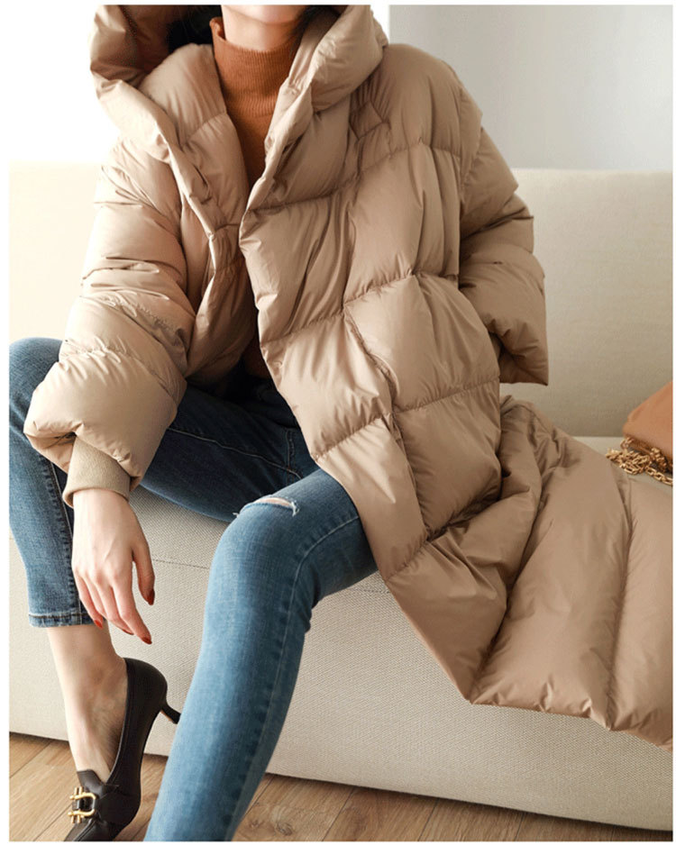 白いガチョウの羽毛のゆったりしたファッションは帽子と膝の中の長いフォアグラの女性を通します。