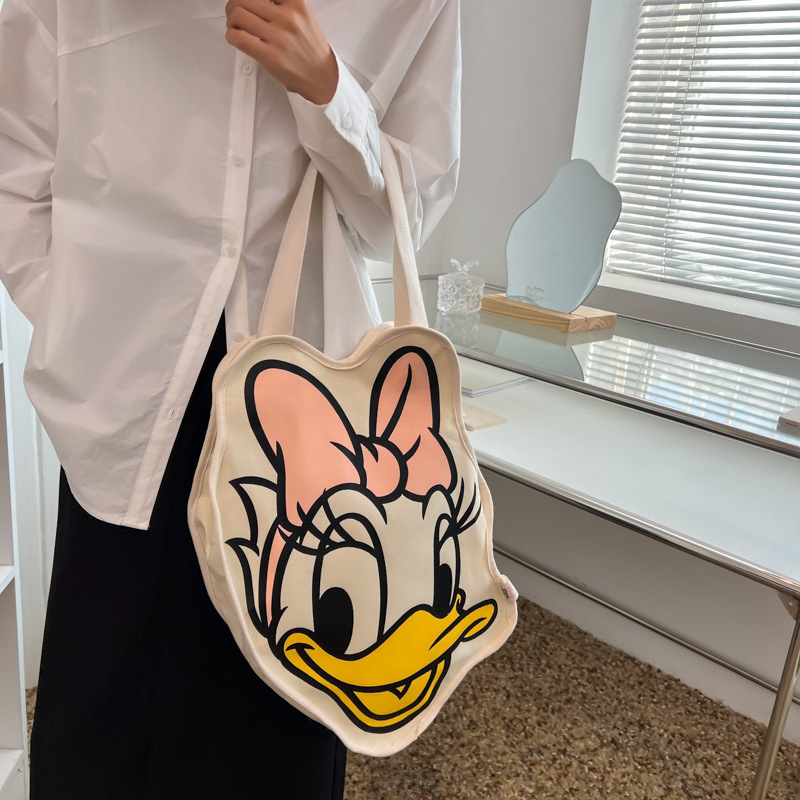 Bolsa de lona para mujeres versión coreana del pato Donald 2025 nueva tarjeta de ocio de gran capacidad bolsa de compras para mujeres de mano