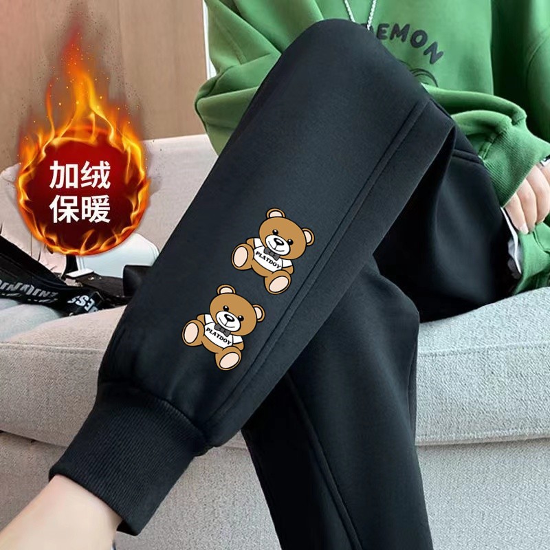 두 개의 노란 곰 나사 입이 있는 검은색 바지와 벨벳