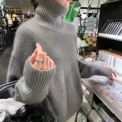 怠惰な風の高襟の純色の外はセーターの女性を着ます。