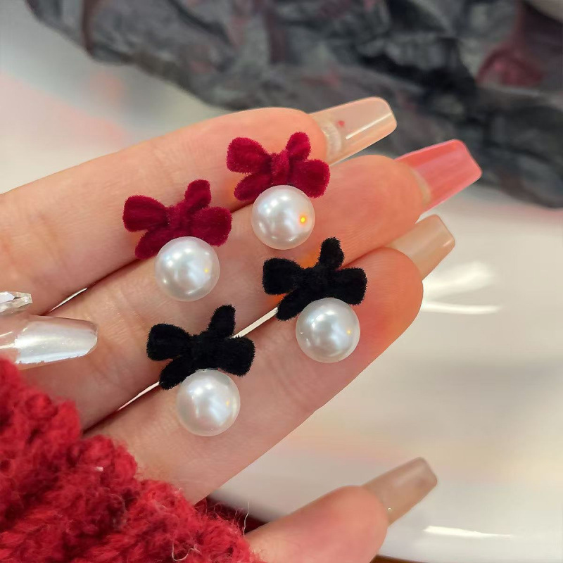 Demi-season small design earrings with bow from pearl