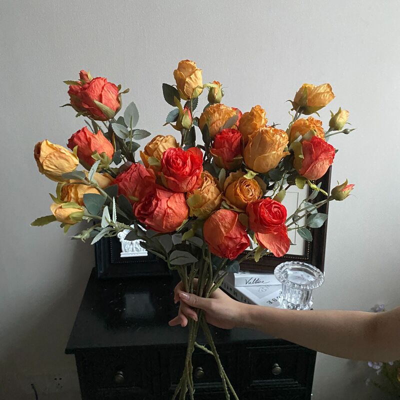 レトロな四頭のフランスのバラの花を焼いて花束の造花の乾いた花を飾って客間の食卓の花の装飾品を飾る|undefined