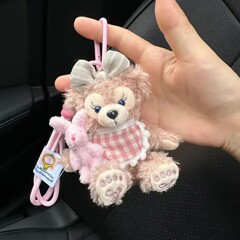 シェリーの青いセーターはウサギのキーホルダーを抱いてぬいぐるみの人形を飾ります。