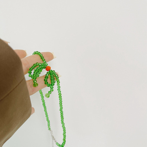 A minimalist and stylish green butterfly knot necklace for women, featuring small, fresh and elegant glass crystal beads, designed as a choker or lockchain.