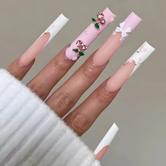 長尺水道管は甲に蝶ネクタイをつけたさくらんぼの花の白いフランス式取り外し可能な完成品の偽爪パッチを着用している