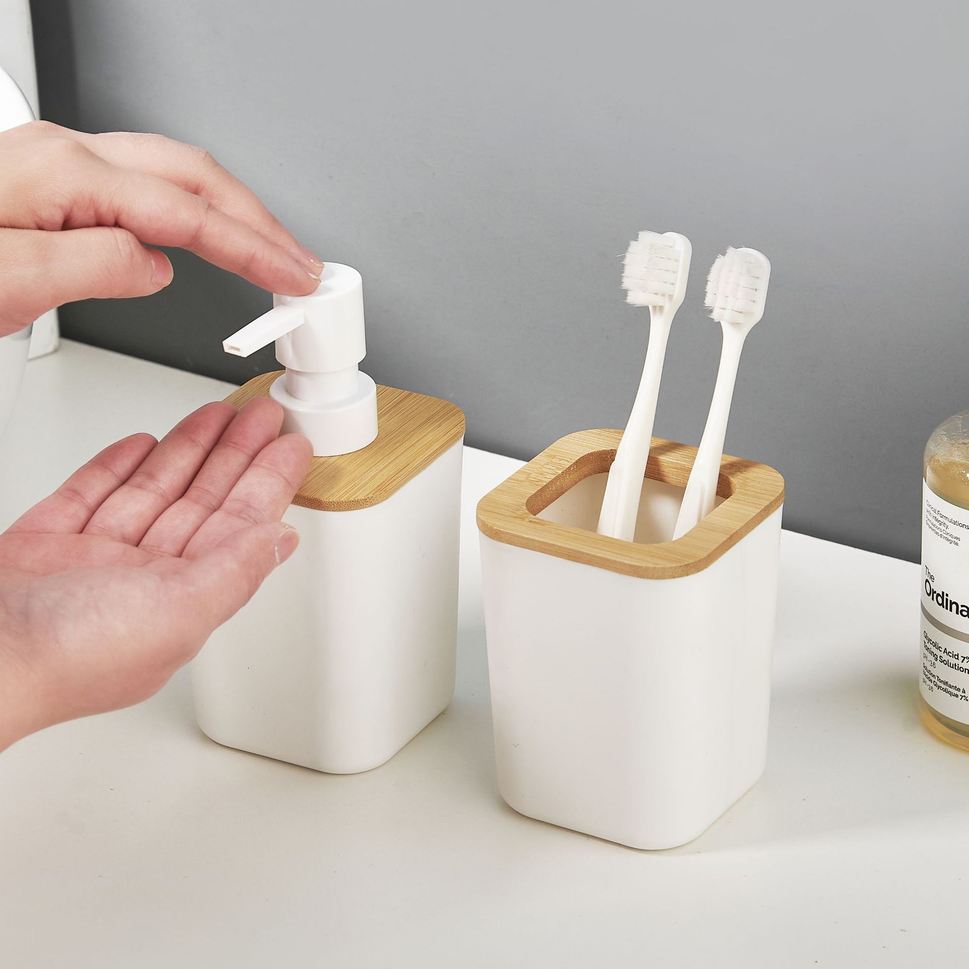 Juego de cuatro piezas de baño de bambú y madera, artículos de tocador de baño simples, soporte para cepillo de dientes, botella de loción, juego de combinación de taza de enjuague bucal