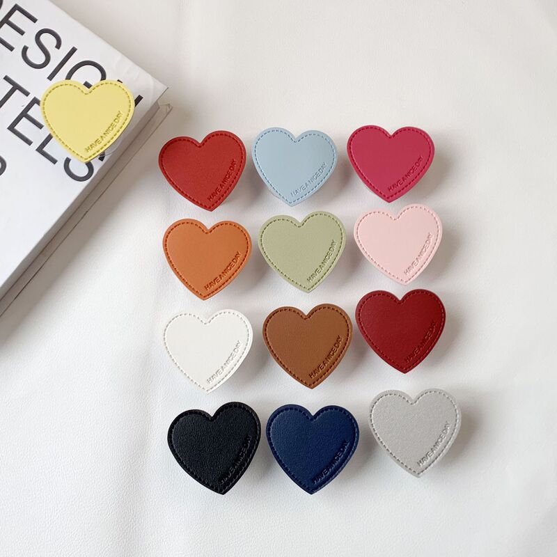 Solid Color Heart-Shaped Mobile Phone Airbag Stand with Adhesive Transparent Base, Leather, Simple and Stylish, Sturdy for Desktop Use