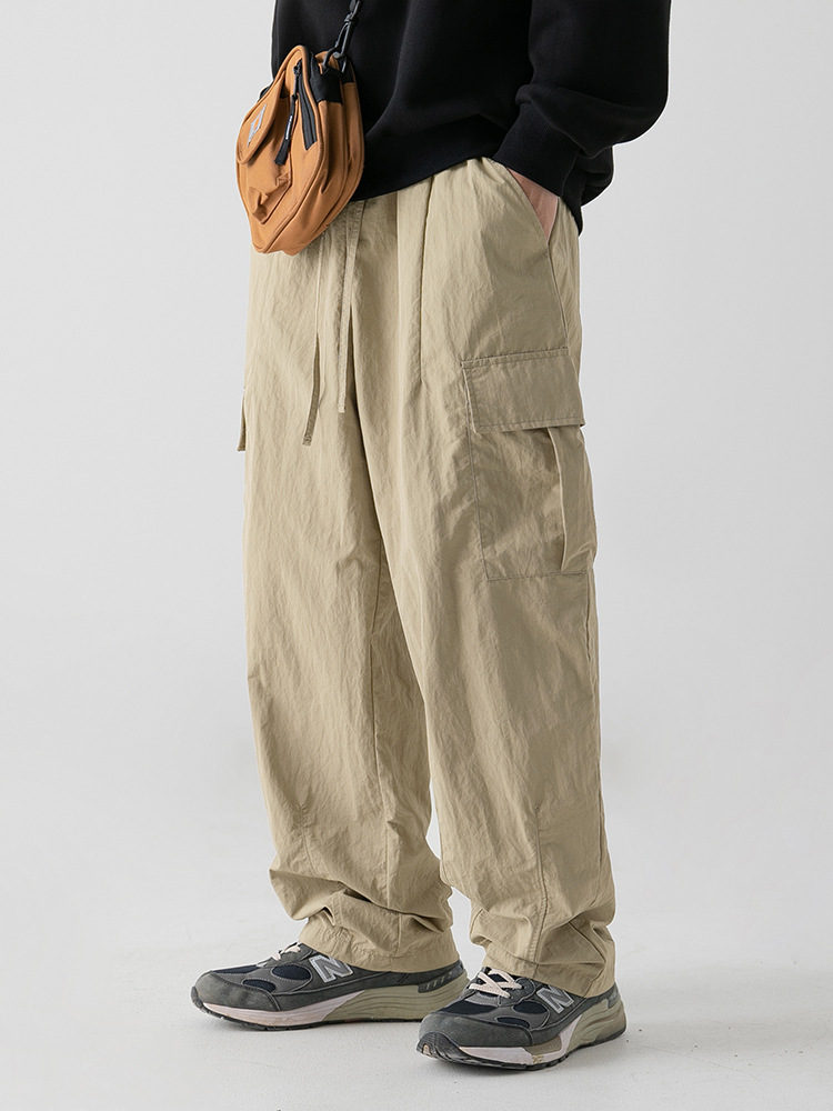 Textura ligeramente arrugada, pantalones de herramientas funcionales antisalpicaduras, estilo de primavera para hombres, pantalones casuales con cordón plisado suelto al aire libre japonés