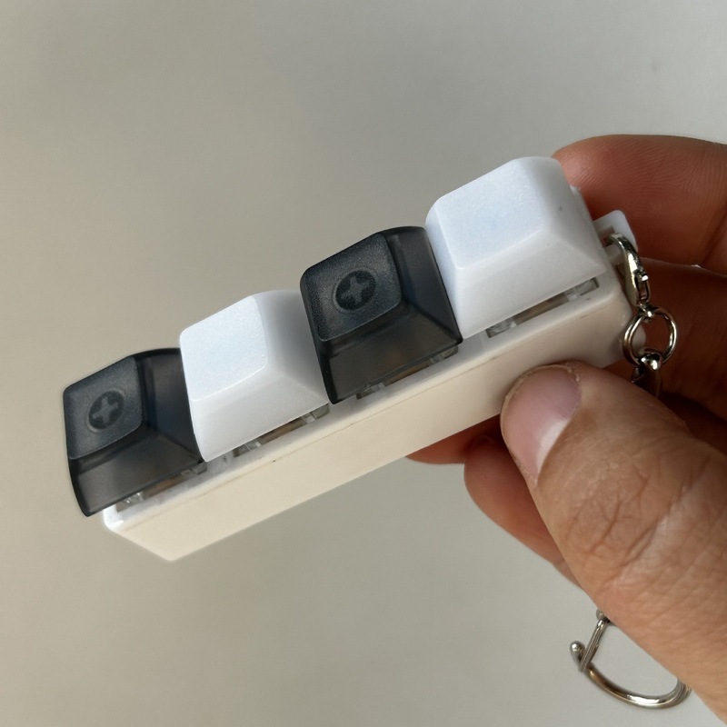 クロスボーダーカラー一字型四ボタンのキーホルダーの指先を押して解凍します。|undefined