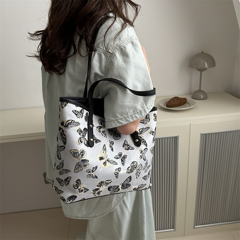 Nueva primavera y verano, nueva bolsa china de gran capacidad, estilo nacional de mariposa bordada bolsa de cubo, bolsa de hombro casual versátil.