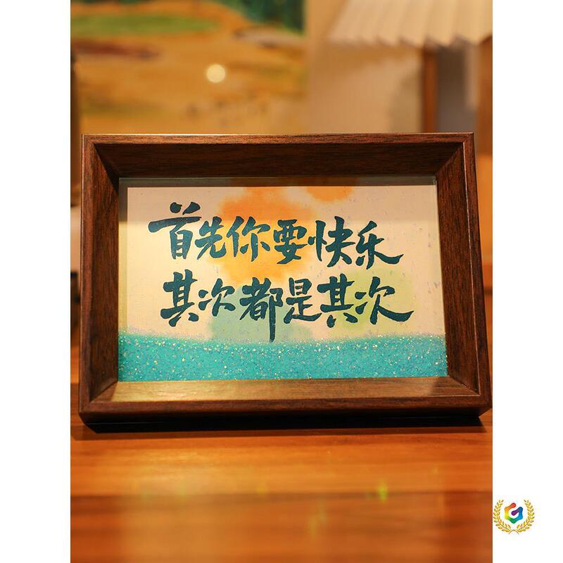 First of All, You Need to Be Happy. Flowing Sand Desktop Text Calligraphy Ornaments, Photo Frames, Table Displays, Handwritten and Hand-Painted Decorations with a National Trend Vibe First of All, You Need to Be Happy. Flowing Sand Desktop Text Calligraphy Ornaments, Photo Frames, Table Displays, Handwritten and Hand-Painted Decorations with a National Trend Vibe