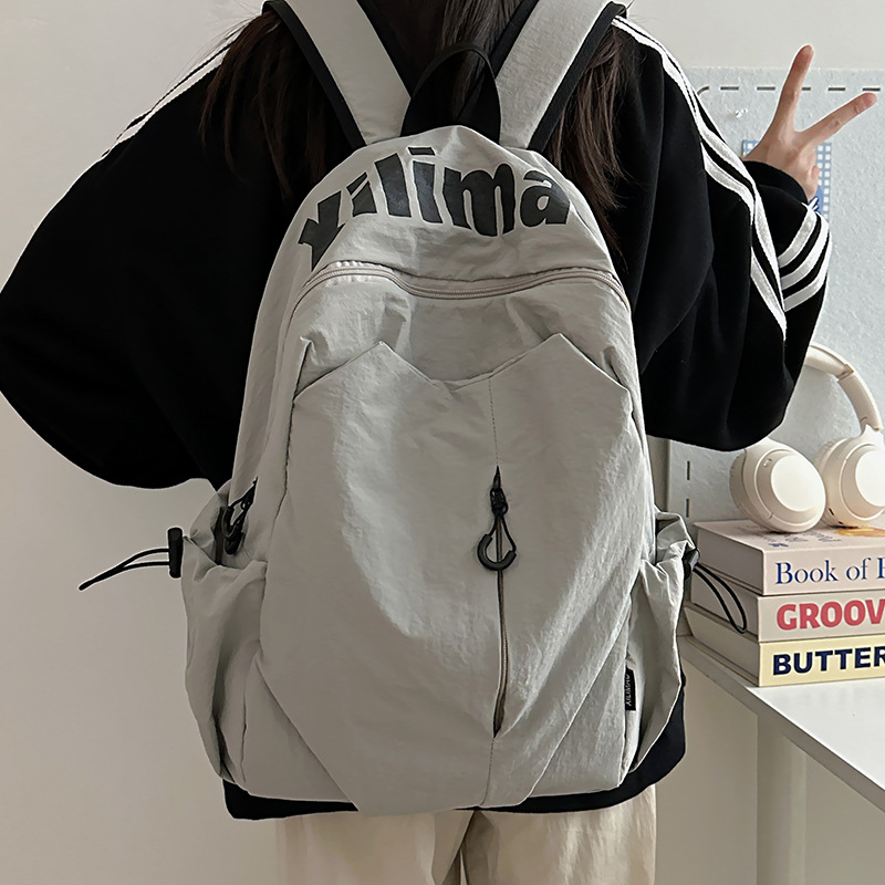 Mochila escolar 2025 nicho ligero y anti-salpicaduras de agua estudiantes de secundaria hombres y mujeres deportes de gran capacidad al aire libre mochila de viaje