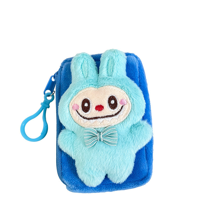 震え音の赤い本が爆発してかわいいぬいぐるみの布の小銭入れのキーホルダーのイヤホンのかばんにプレゼントを掛けます。|undefined