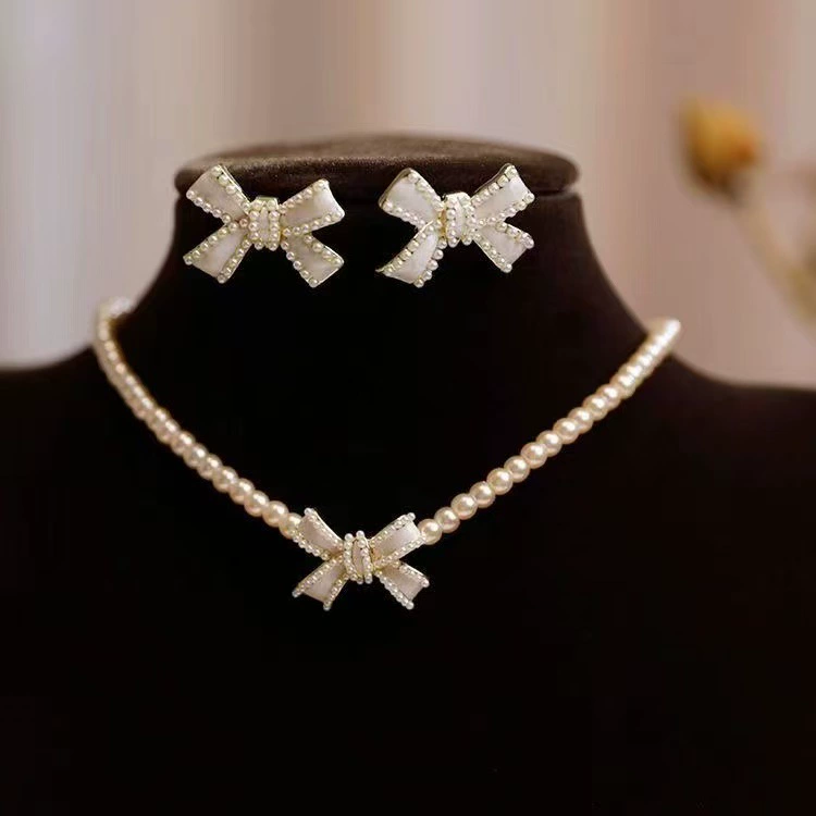 Простой и стильный новый комплект ожерелья и сережек с жемчужным бантом для женщин, универсальный аксессуар нишевого дизайна.