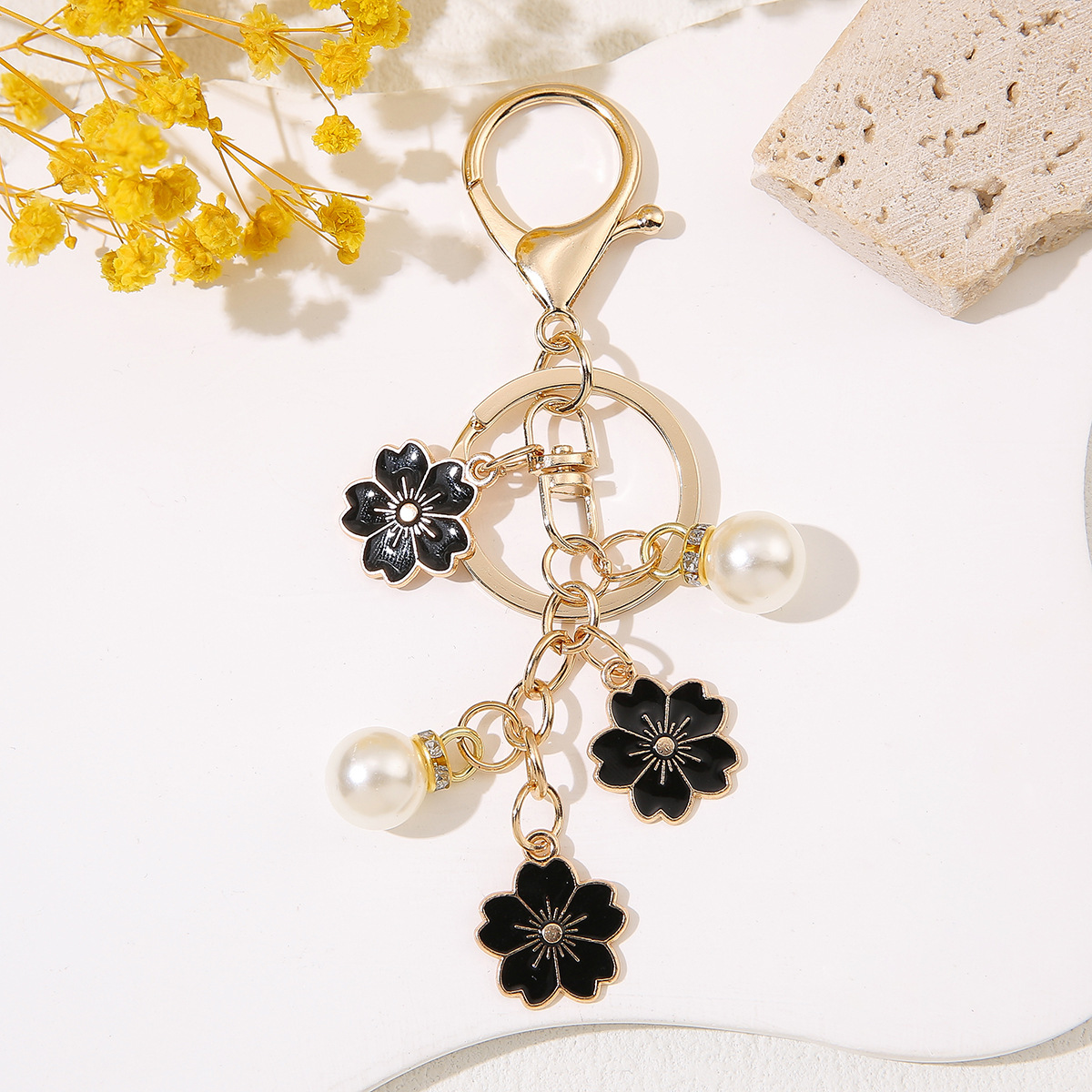 Venta al por mayor de llaveros de flores de cerezo japoneses que caen a mano, adornos de bolsos de mujer que gotean aceite, colgantes de perlas para parejas de novias