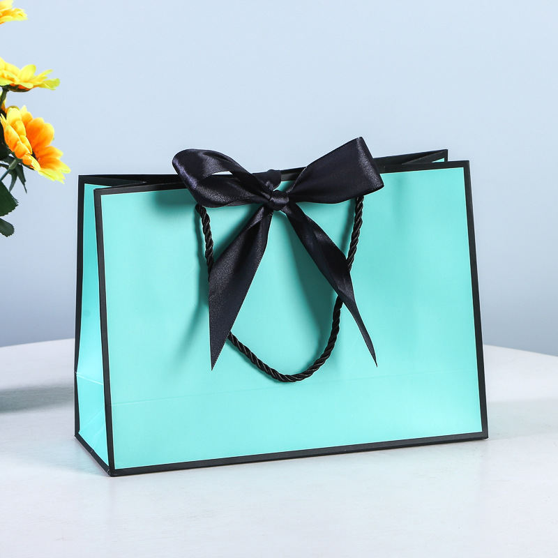 Bolsa de regalo de lazo Bolsa de papel Bolsa de embalaje de ropa Bolsa de cosméticos al por mayor Bolsa de compras Bolsa de mano con logotipo impreso